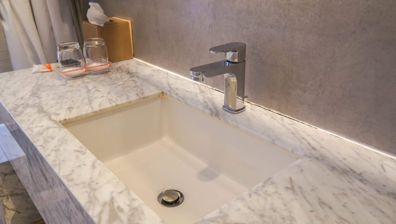 faucet and luxury marble washbasin in hotel bathroom