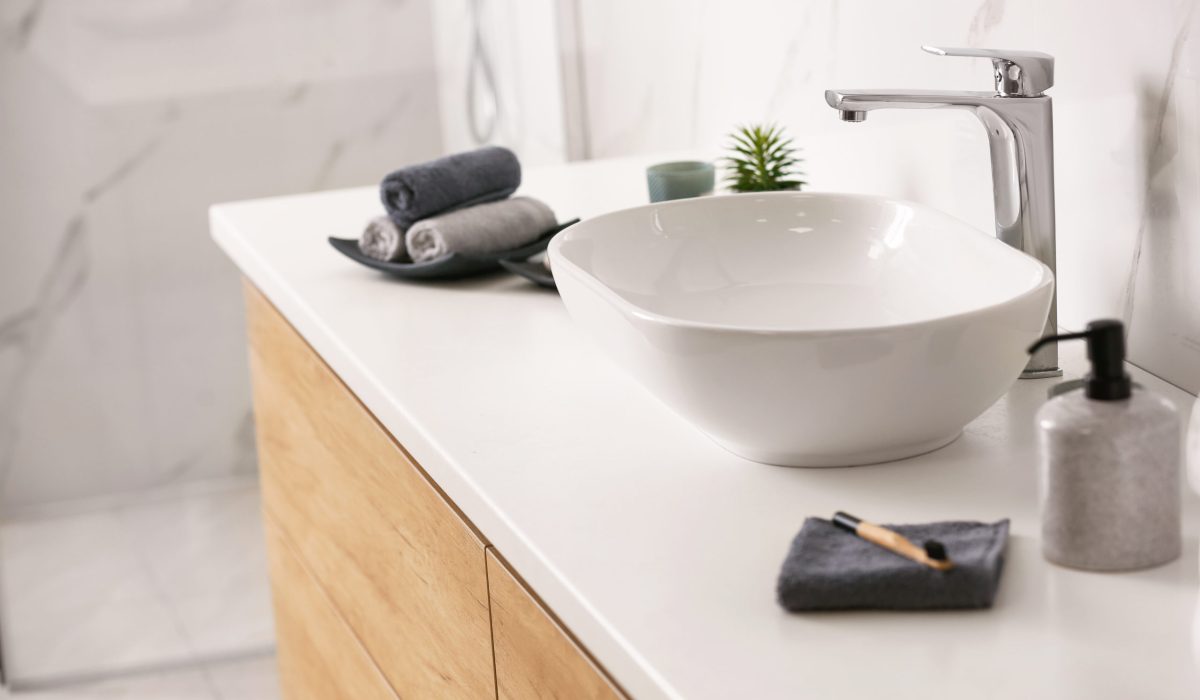 Stylish vessel sink on light countertop in modern bathroom
